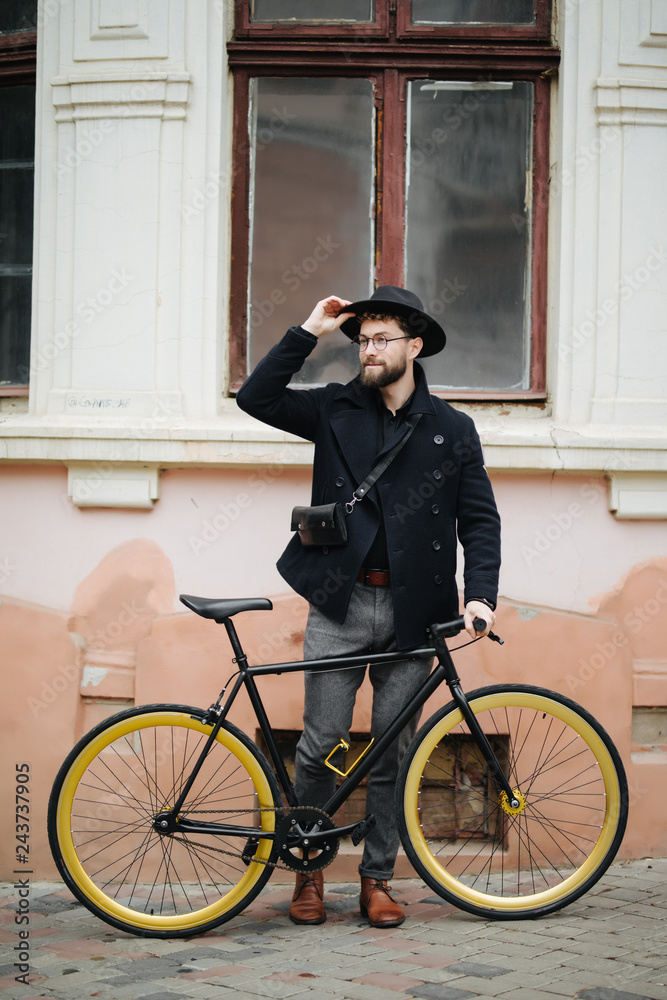 Handsome bearded hipster man holding bicycle in the city street Handsome bearded hipster man holding bicycle in the city street