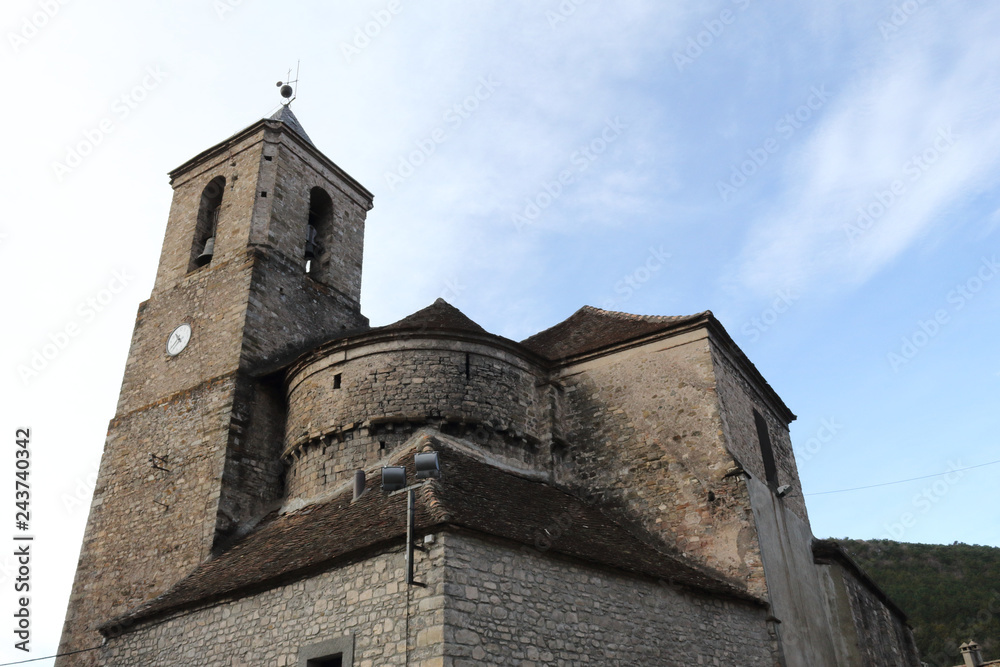 The stone made, modern Saint Martin's church (Iglesia de San Martin) and its bell tower with clock in the rural village of Hecho, Aragon, Spain The stone made, modern Saint Martin's church (Iglesia de San Martin) and its bell tower with clock in the rural village of Hecho, Aragon, Spain