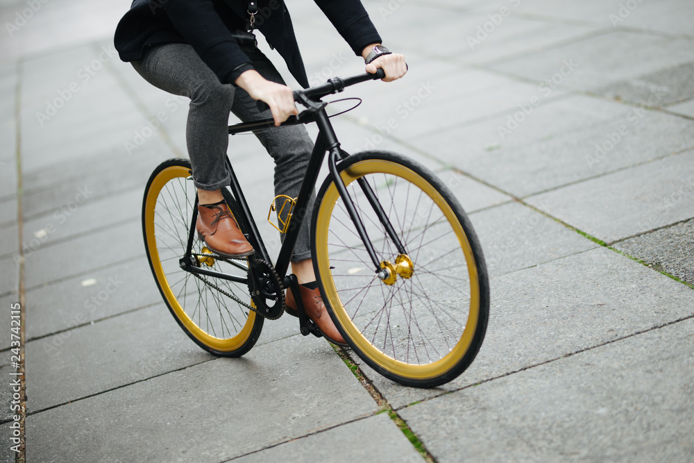 Cropped picture of handsome young man with bicycle walking outdoors Cropped picture of handsome young man with bicycle walking outdoors