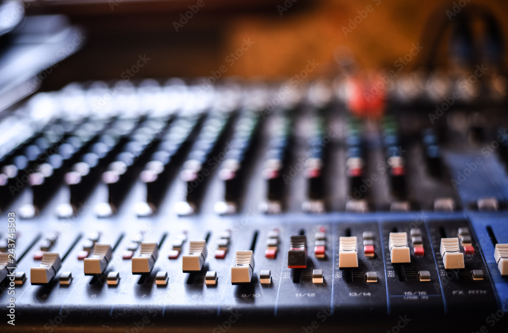 od adjusters and red buttons of a mixing console. It is used for audio signals modifications to achieve the desired output. Applied in recording studios, broadcasting, television.