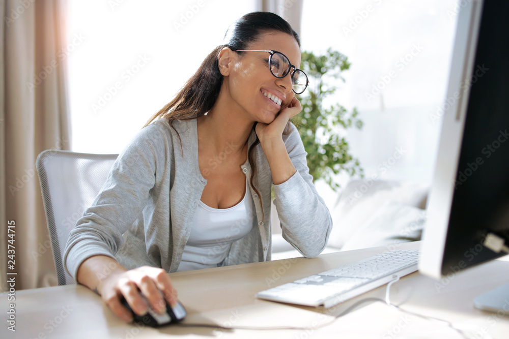 Pretty young business woman working with her computer in the office.