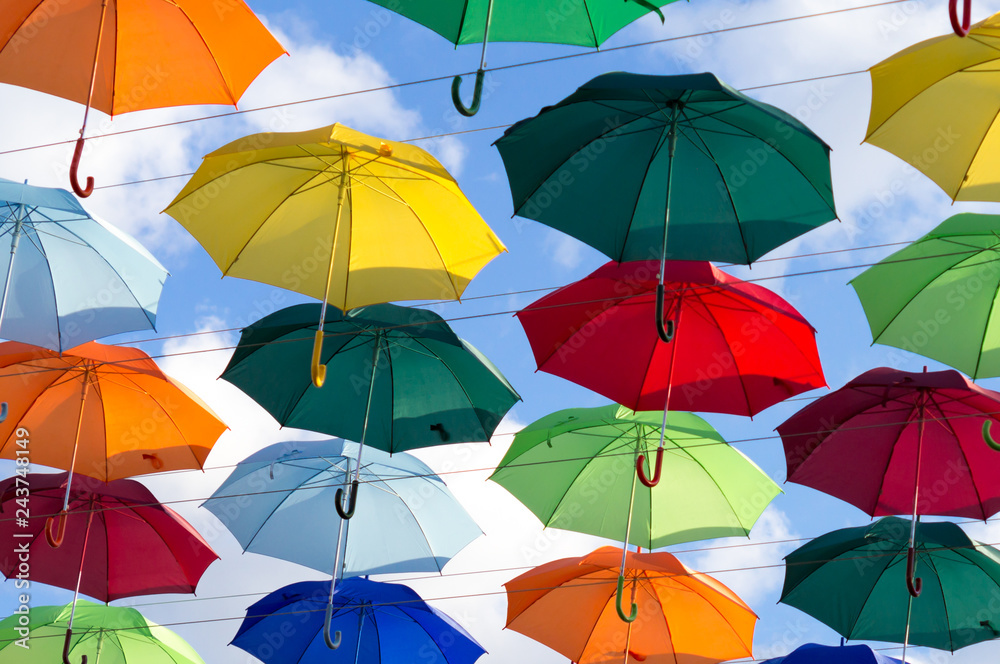 umbrellas of different colors soar in the summer sky