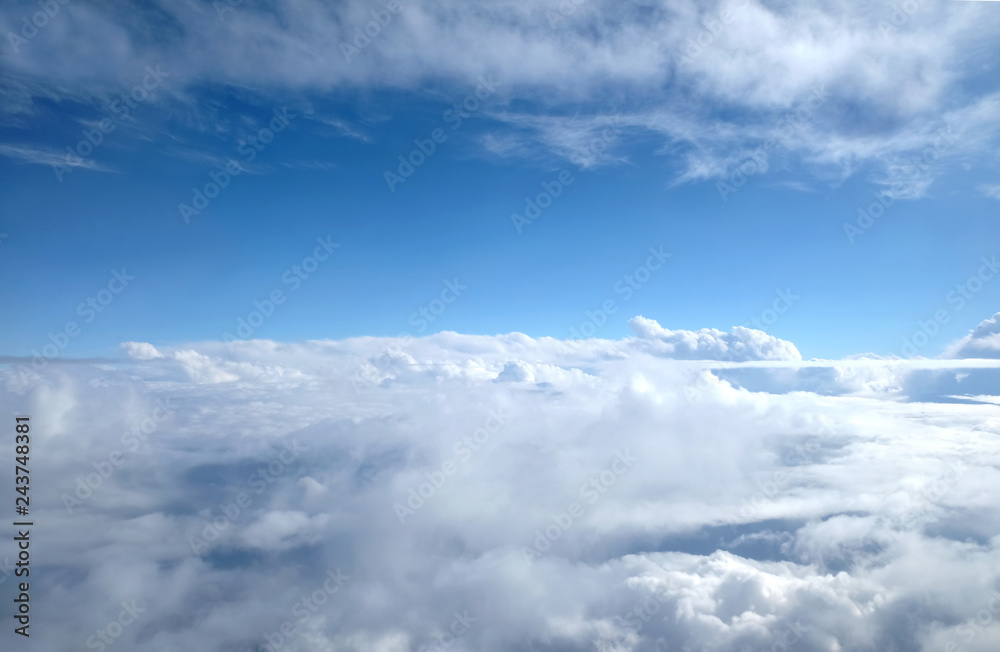 Beautiful sky landscape with view from the plane above dense white clouds high in the stratosphere on a sunny day horizontal photo