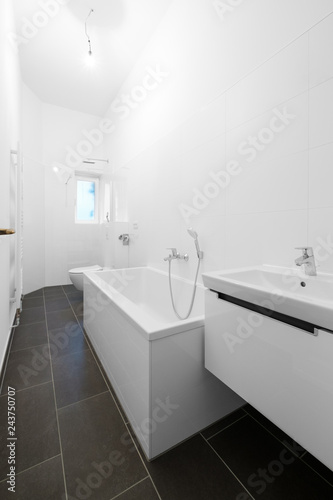 white bathroom with bathtub and shower after renovation