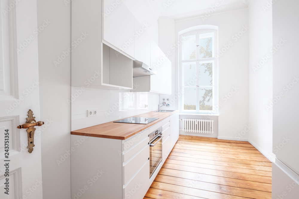 new built-in kitchen with white furniture and wooden floor new built-in kitchen with white furniture and wooden floor