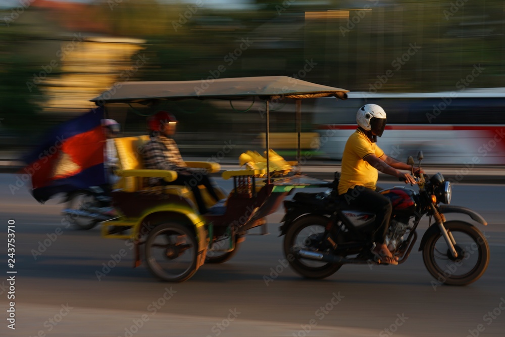 Obraz premium Siem Reap,Cambodia-Januay 13, 2019: A panning of motorcycle with trailer on National Highway 6 in Siem Reap, Cambodia