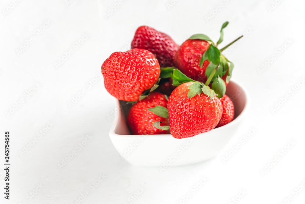 Fresh strawberries in a heart shaped bowl isolated on white background. Fresh strawberries in a heart shaped bowl isolated on white background.
