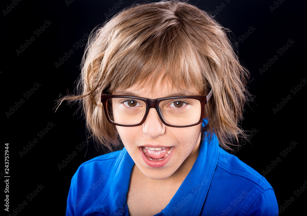 Emotional Portrait of Attractive Caucasian little Student Girl with Eyeglasses. Funny cute Smiling Child Looking at Camera on Black Background.