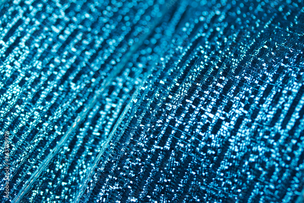 Vibrant blue metallic ribbon macro abstract background with bokeh