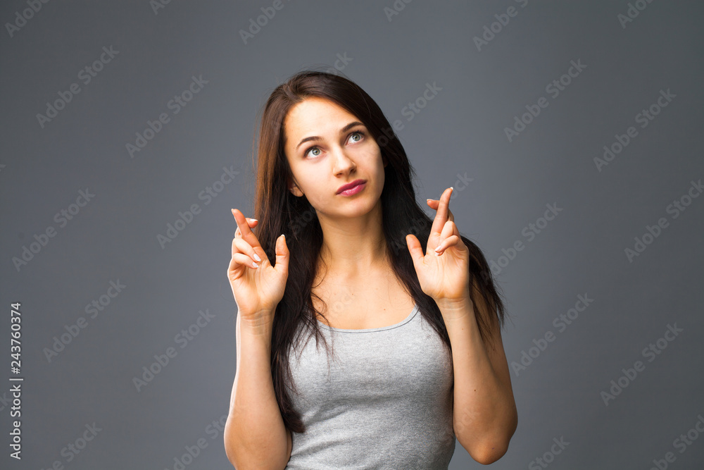 Emotions concept. Glad dark haired beautiful satisfied girl beggs God to help her Emotions concept. Glad dark haired beautiful satisfied girl beggs God to help her