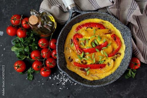 Frittata with sweet peppers in iron pan. Top view with copy space. Omelette with vegetables.