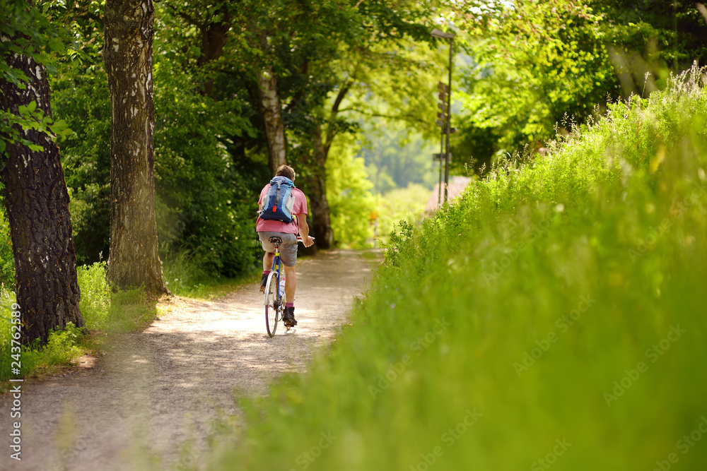 Obraz premium Sportive man cycling in sunny park in hot summer day. Switzerland, Europe