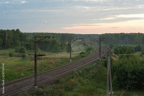 Bending railroad at dawn in a beautiful forest
