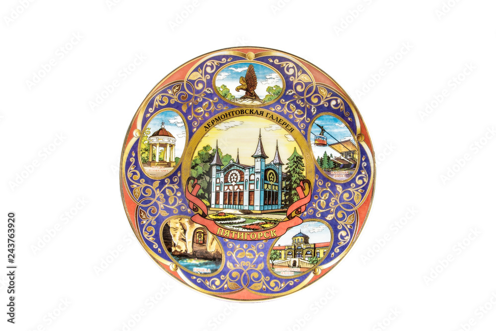 ceramic souvenir toy in the form of plate with color painting on isolated white background reflecting the national Russian culture with the inscription in Russian: Lermontovskaya gallery Pyatigorsk