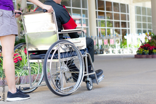 Young man in wheelchair with his assistant. photo