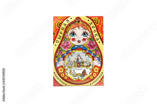 ceramic souvenir toy in form of matryoshka with color painting on isolated white background reflecting the national Russian culture with the inscription in Russian: Ceramic cheese board Russian beauty