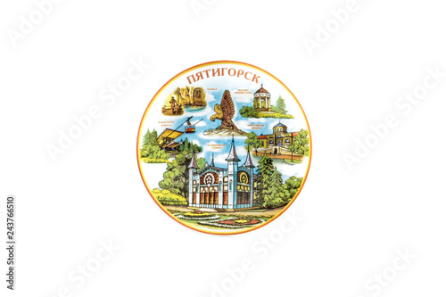 ceramic souvenir toy in the form of plate with color painting on isolated white background reflecting the national Russian culture with the inscription in Russian: the name of the city of Pyatigorsk