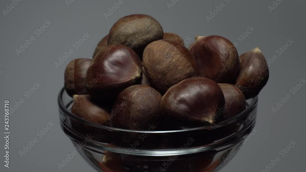 Chestnut. Close up. Heap of raw unroasted sweet chestnut in a bowl in rotation. Food background. gray background, studio shot. Healthy food diet concept. Gastronomy and organic food concept. Chestnut. Close up. Heap of raw unroasted sweet chestnut in a bowl in rotation. Food background. gray background, studio shot. Healthy food diet concept. Gastronomy and organic food concept.
