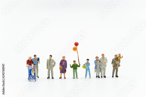 Miniature people, family and children with colorful balloons  standing isolated on white background. International Day of Families