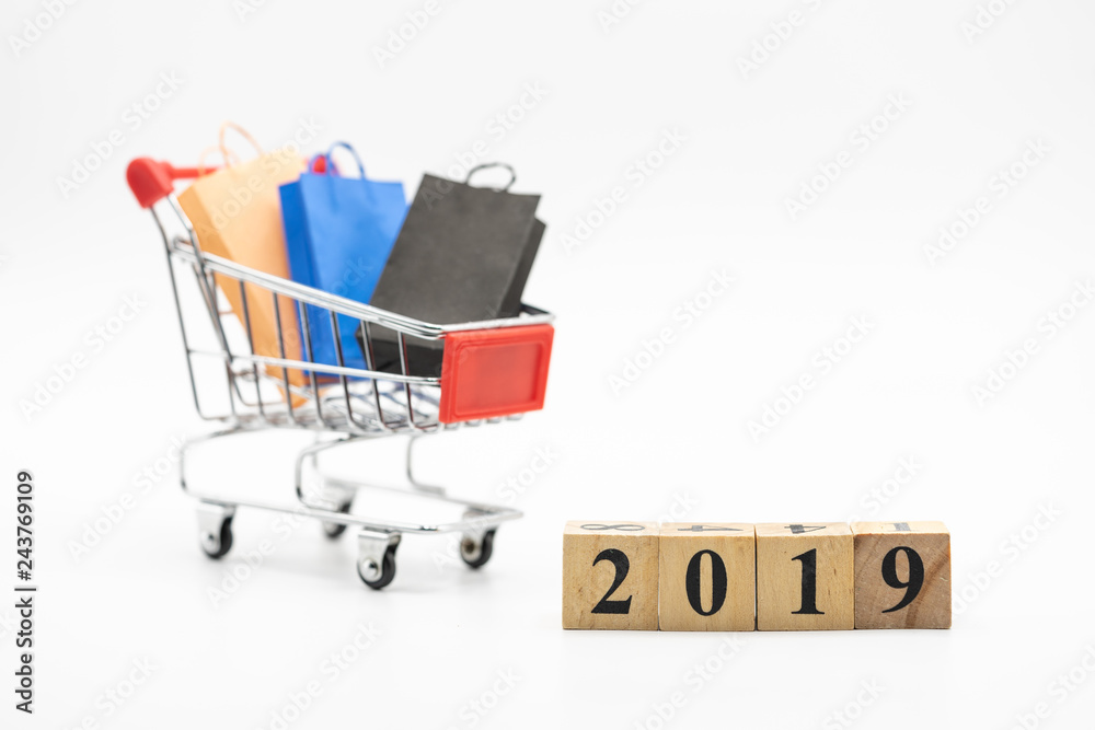 Wood block 2019, shopping cart, and shopping bags isolated on white background using as background. Black Friday, boxing day, mid year sales,and year end sales.