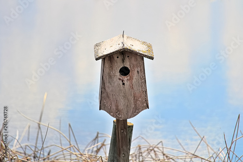 A birdhouse against a blue blurry background