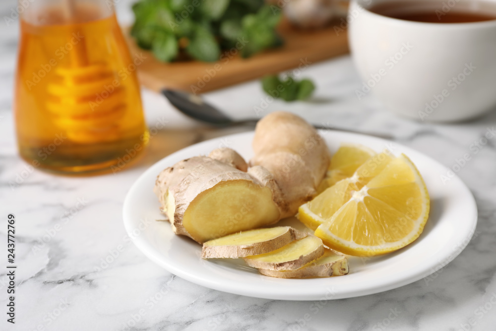 Plate with lemon and ginger on marble table, space for text. Cough remedies Plate with lemon and ginger on marble table, space for text. Cough remedies