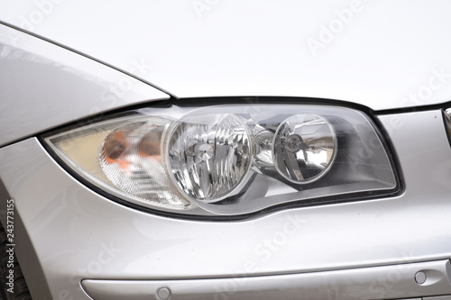 shiny headlights on a silver  car © Laurenx