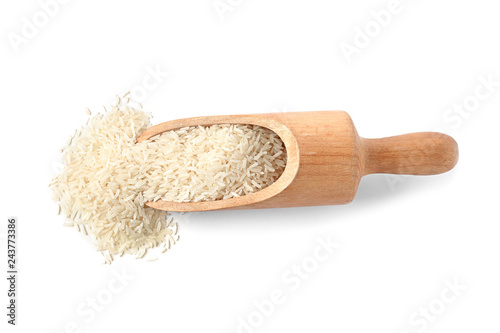 Scoop with uncooked long grain rice on white background, top view