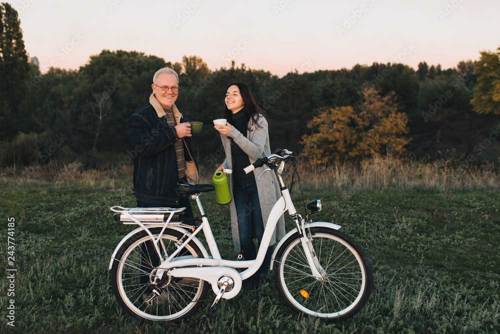 Thermos picnic. Ride a bike. Keep warm hot coffee from a thermos. Bicycle lifestyle. Father and daughter spend time together.