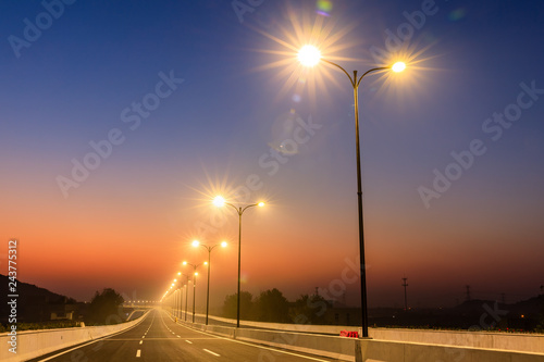 Canvastavla City road and bright street lights landscape at sunset