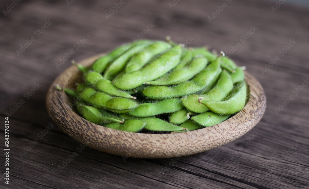 Young soy beans or edamame on wood background. Young soy beans or edamame on wood background.