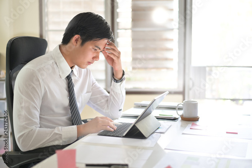 Businessman analyzing financial statistics displayed on the tablet screen.