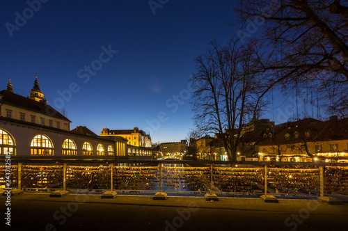 View of Ljubljanica river and tromostovje in old city center decorated with Christmas lights in the dark, Ljubljana, Slovenia photo