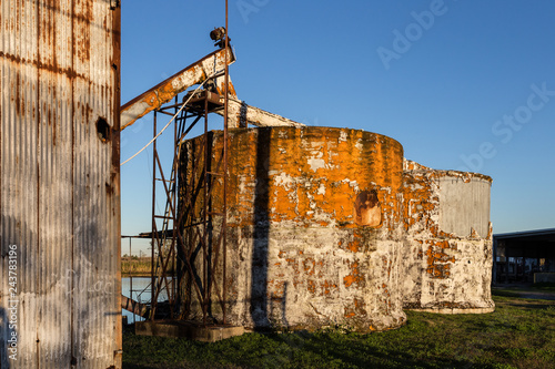 Two large tanks with peeling paint on green grass