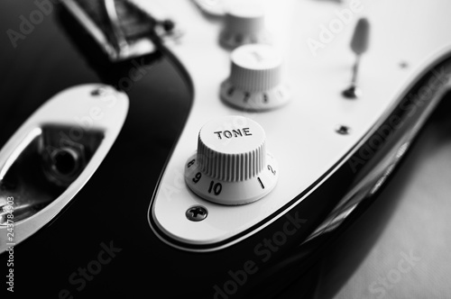 Photo Close-up of electric guitar, in black and white.