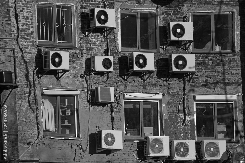 Obraz premium black and white air conditioners on the wall of an old brick building
