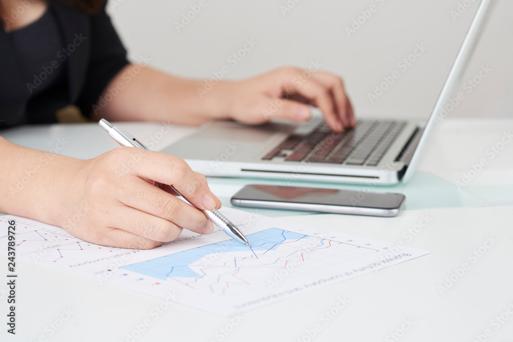 Close-up image of financial analyst working with report and analyzing sales Close-up image of financial analyst working with report and analyzing sales