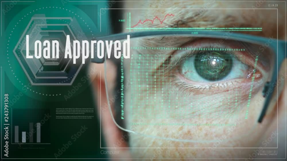 A close up of a businessman eye controlling a futuristic computer system with a Business Loan Approved concept.