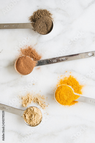 Overhead view of varieties of spices on marble table