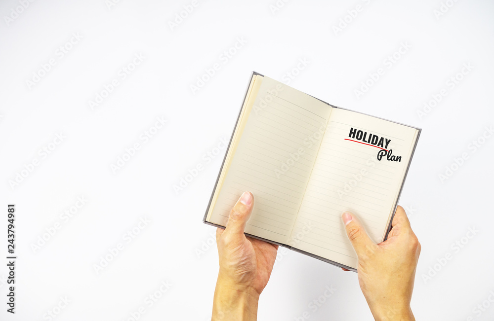 Holiday plan on notebook with hand holding on white background Holiday plan on notebook with hand holding on white background