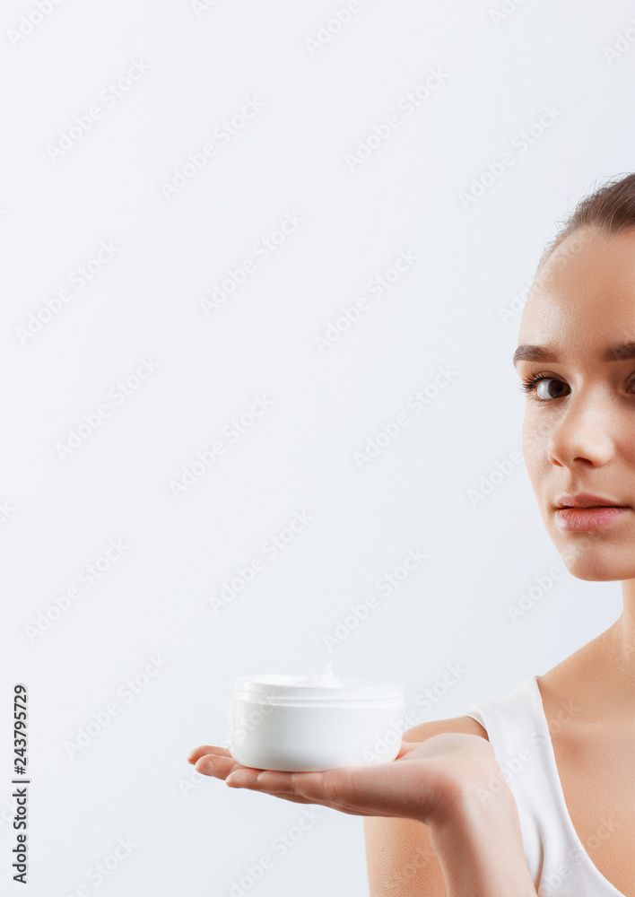 Beauty Concept. woman holds a cream in her hand and spreads it on her face to moisturize her skin and wrinkle from impurities. body care, skincare.Taking good care of her skin Beauty Concept. woman holds a cream in her hand and spreads it on her face to moisturize her skin and wrinkle from impurities. body care, skincare.Taking good care of her skin