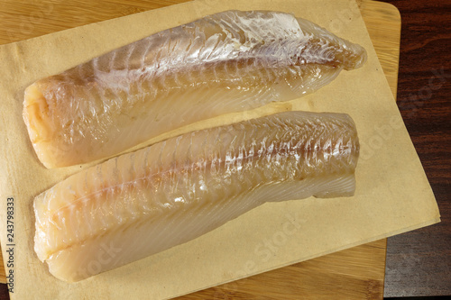 Raw cod fillet on a cutting board. Healthy eating. photo