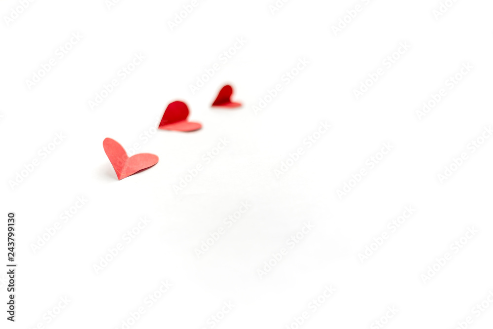 three red paper hearts isolated on white background, close up focused on nearest heart three red paper hearts isolated on white background, close up focused on nearest heart