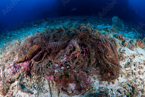 An abandoned Ghost fishing net entangled on a tropical coral reef in Asia