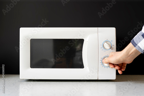 closeup photo of man use microvave oven to heat the food f