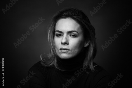 Dramatic black and white portrait of a beautiful woman on a dark background © Restyler