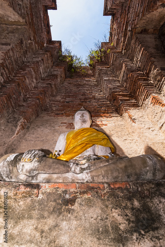 Old buddha statue with old wall brick of Wat Nakhon Luang Tample,Prasat Nakhon Luang in Ayutthaya,Thailand.