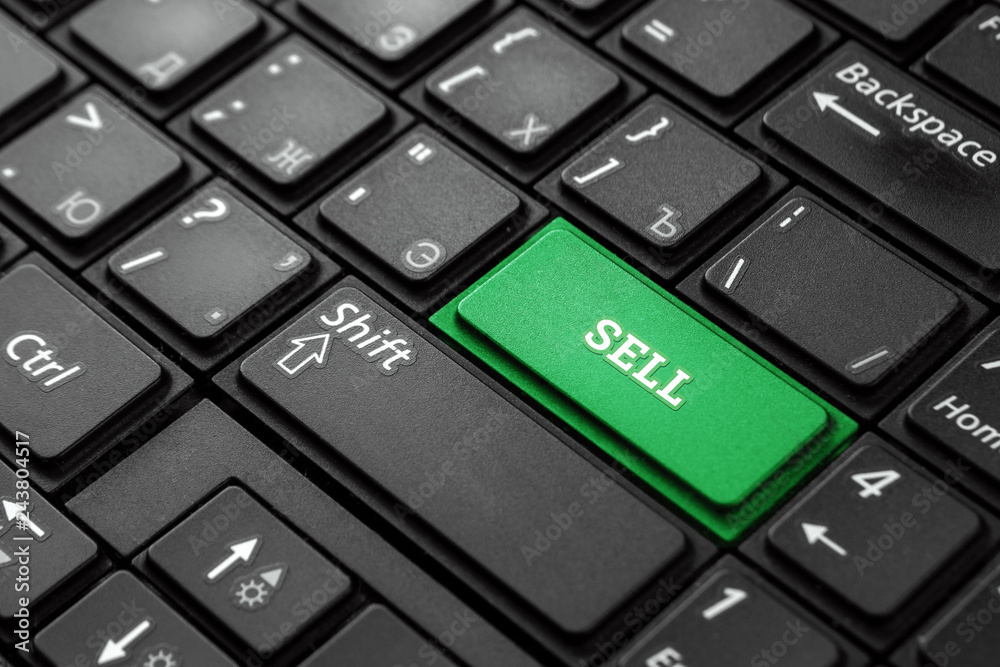Closeup of a green button with the word Sell, on a black keyboard. Creative background, copy space. Concept magic button, business, stock, discount, online. Closeup of a green button with the word Sell, on a black keyboard. Creative background, copy space. Concept magic button, business, stock, discount, online.