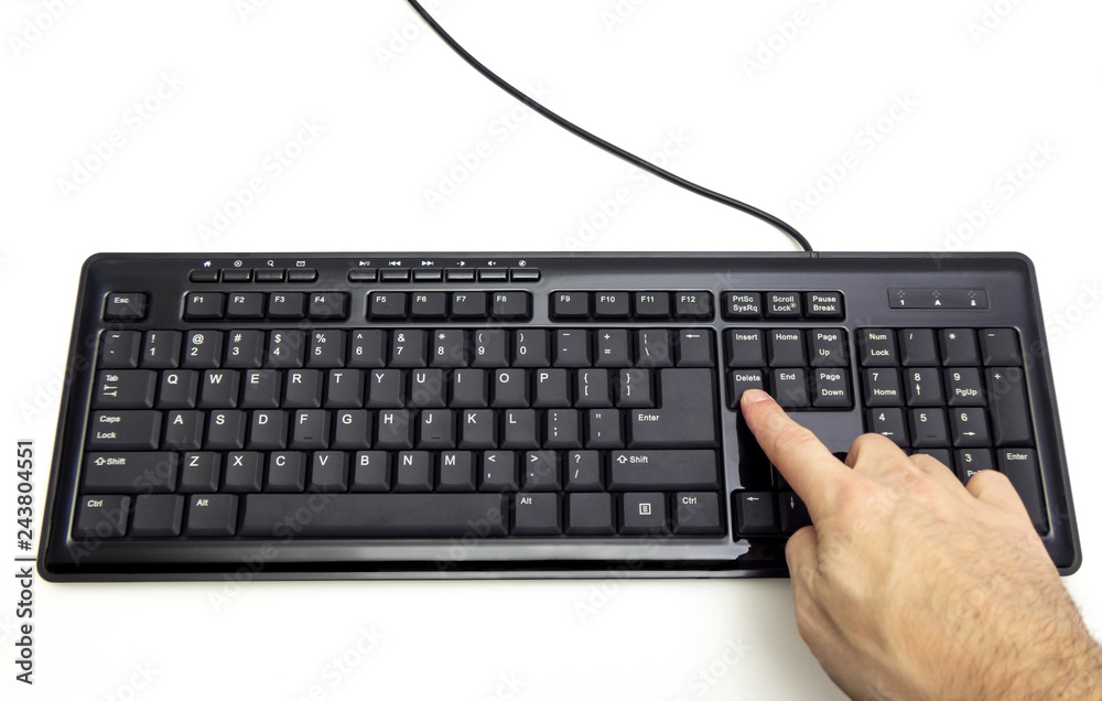 Finger pressing Delete button on the black keyboard Finger pressing Delete button on the black keyboard