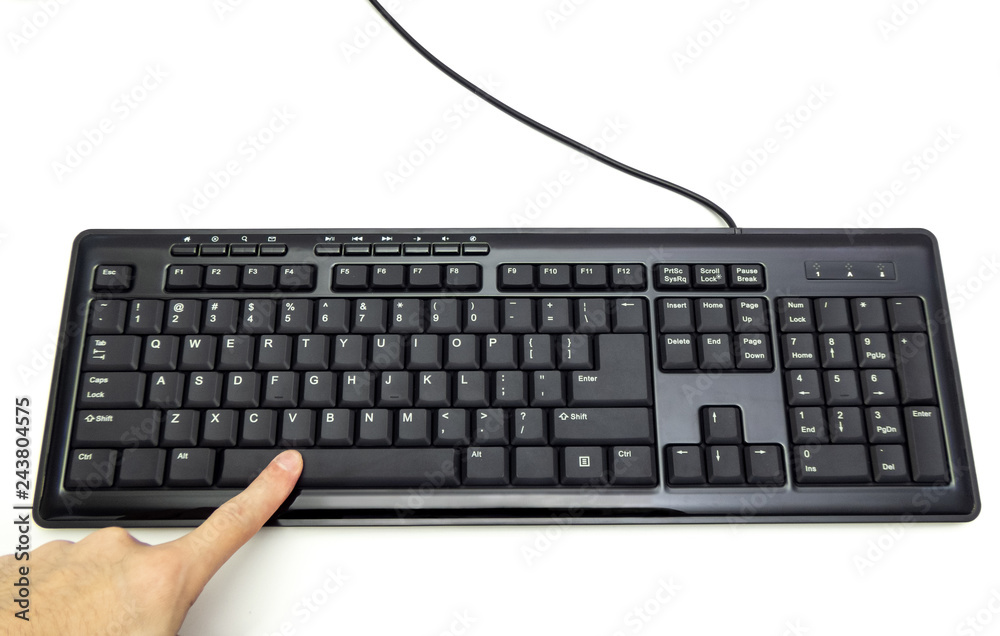 Finger pressing Spacebar button on the black keyboard Finger pressing Spacebar button on the black keyboard